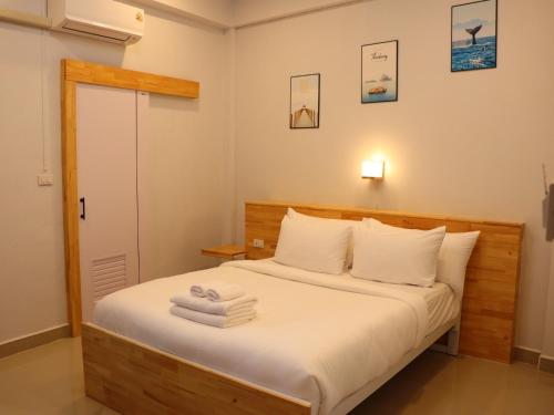 a bedroom with a bed with towels on it at Moya Boutique Hotel in Betong