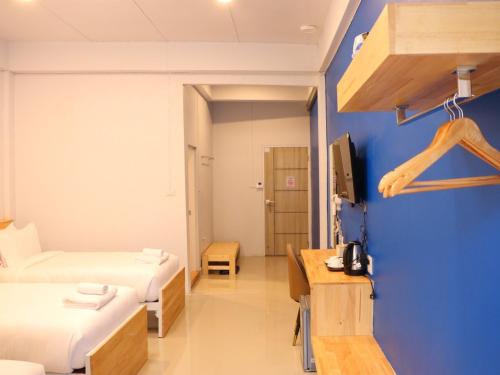 a room with two beds and a blue wall at Moya Boutique Hotel in Betong