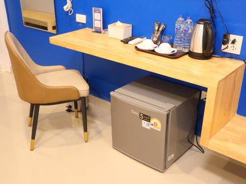 a desk with a chair and a table with a trash can at Moya Boutique Hotel in Betong