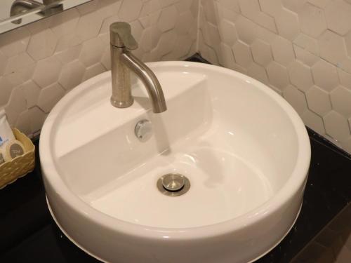 a white sink with a faucet in a bathroom at Moya Boutique Hotel in Betong