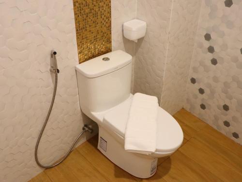 a white toilet in a bathroom with a shower at Moya Boutique Hotel in Betong