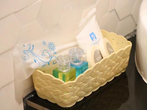 a basket with three bottles of perfume on a table at Moya Boutique Hotel in Betong