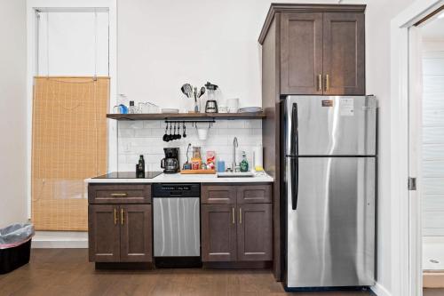 a kitchen with a stainless steel refrigerator and wooden cabinets at Cute & Cozy - Perfect for Business or Leisure in Covington