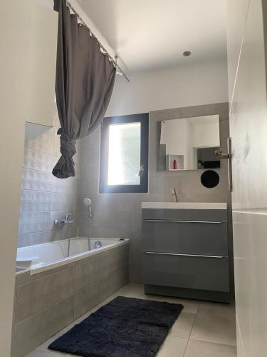 une salle de bain avec une baignoire et un lavabo dans l'établissement Belle maison de garrigue, à Nîmes