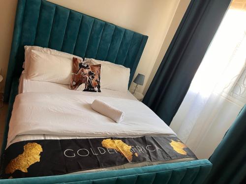 a bedroom with a bed with a blue headboard at Kamona Living 3 Zimmer Apartment in Namugongo