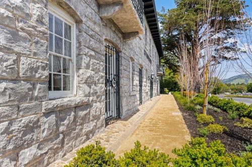 a stone building with a window and a sidewalk at Deluxe King Suite at the Historic Stonehouse Inn! in Santa Rosa