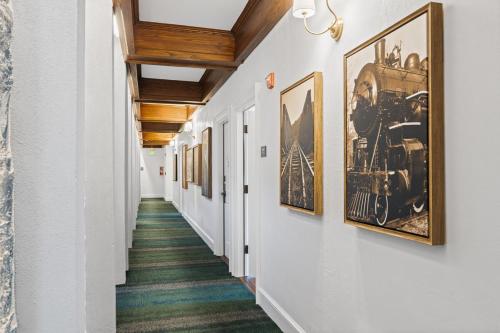 a hallway with framed photographs on the walls and a hallwayngthngthngthngthngth at Deluxe King Suite at the Historic Stonehouse Inn! in Santa Rosa