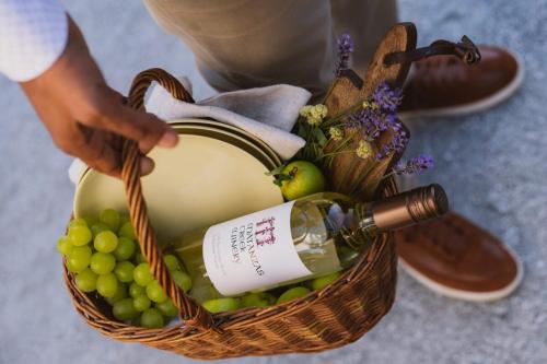 a basket with a bottle of wine and grapes at Deluxe King Suite at the Historic Stonehouse Inn! in Santa Rosa