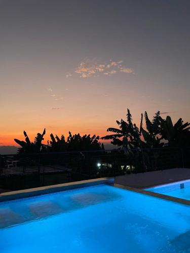 a swimming pool with a sunset in the background at Alojamiento rural san joaquin in Quimbaya