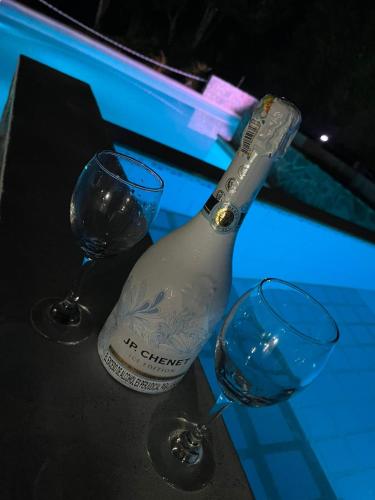 a bottle of wine and two glasses on a table at Alojamiento rural san joaquin in Quimbaya