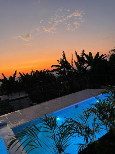 a swimming pool with a sunset in the background at Alojamiento rural san joaquin in Quimbaya
