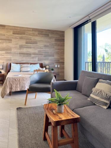 a living room with a couch and a bed at Chic Loft Steps from the Beach in Holbox Island