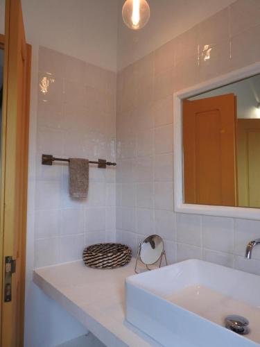 a bathroom with a white sink and a mirror at Casas da Serra d'Ossa - Casa da Horta in Glória