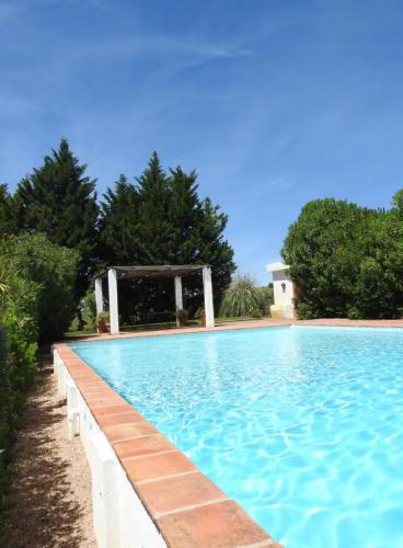 a large blue swimming pool with a gazebo at Casas da Serra d'Ossa - Casa da Horta in Glória