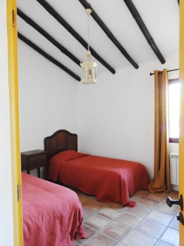 a bedroom with two beds with red sheets at Casas da Serra d'Ossa - Casa da Horta in Glória