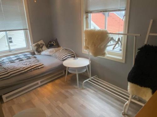 a bedroom with a bed and a table and a window at 200 M TIL ALT to everything in Egersund