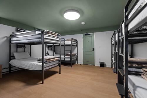 a room with several bunk beds in it with a light at HI Halifax Heritage House Hostel in Halifax