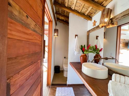 a bathroom with a sink and a wooden wall at Pousada Refúgio Verde Trancoso in Trancoso