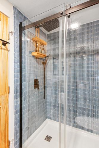 a bathroom with a shower with blue tiles at Lakeshore Vermont in Colchester