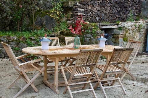 une table en bois avec quatre chaises autour dans l'établissement Villa Antoinette, à Saint-Nectaire