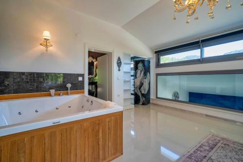 un ampio bagno con una grande vasca e una finestra di Villa Yakamoz a Fethiye