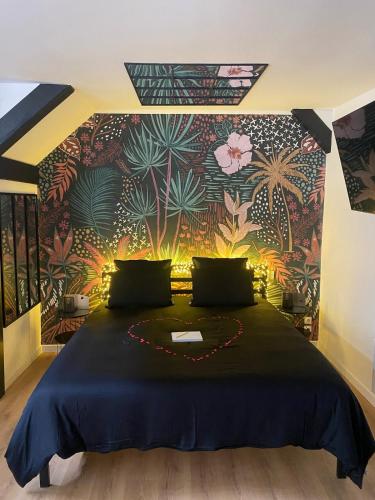 - une chambre avec un grand lit et un mur fleuri dans l'établissement Love room Spa 