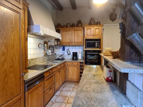 a kitchen with wooden cabinets and a counter top at gite au jardin de grand-père in Fougères-sur-Bièvre