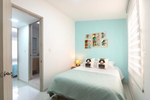 a bedroom with a bed with a blue wall at TU CASITA EN SALENTO - WIFI 300mbps, ubicación perfecta, cocina equipada y Netflix incluído in Salento