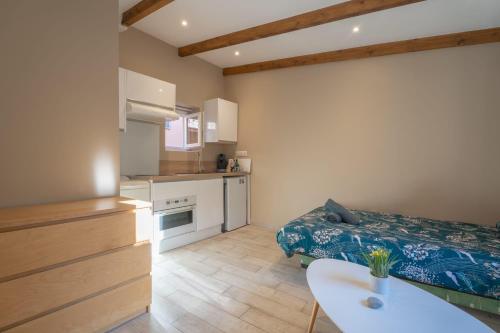 Cette petite chambre comprend un lit et une cuisine. dans l'établissement Studio lumineux à 10 min de la plage, à Nice