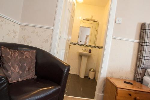 a living room with a chair and a mirror at Bank Guest House in Wick