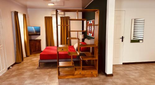 a bedroom with a bunk bed with a red bed at Villa Josephine in Paramaribo