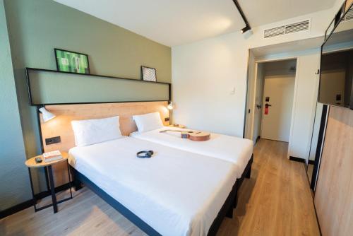 a bedroom with a large white bed in a room at Hotel ibis Guimaraes in Guimarães