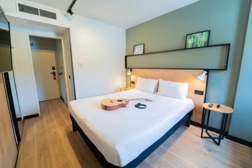 a bedroom with a large white bed in a room at Hotel ibis Guimaraes in Guimarães