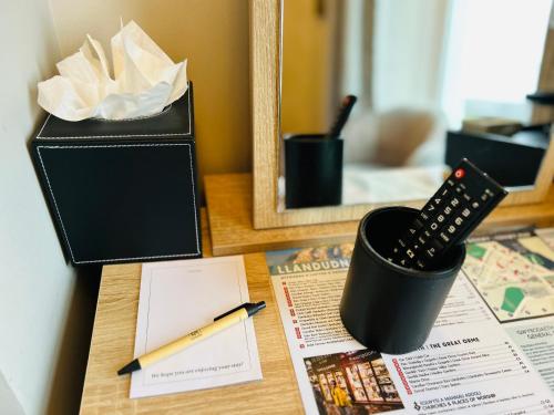 a desk with a remote control and a box at Hotel No5, Beachfront with Free Private Car Park in Llandudno