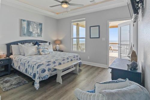 una camera da letto con un letto, una sedia e una finestra di Bella Luna - Stunning 4BR Beachfront w Cargo Lift a Bolivar Peninsula