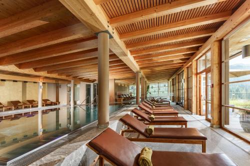 an indoor pool with a row of chairs in a building at Naturhotel Edelweiss Wagrain in Wagrain