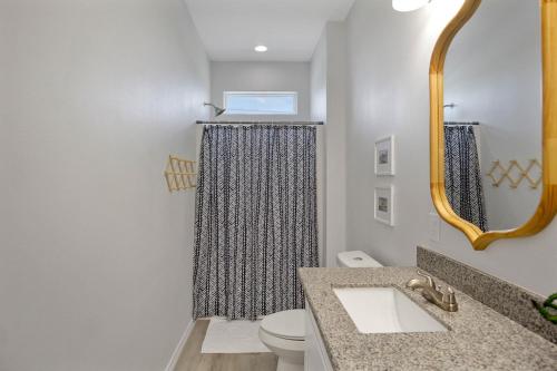 a bathroom with a shower curtain and a toilet at Spacious Beachfront 5BR with Gorgeous Ocean views - Blue Footed in Bolivar Peninsula