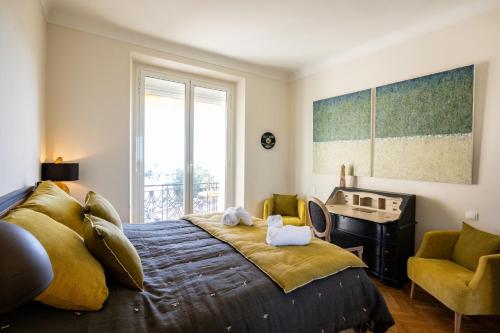 une chambre avec un lit, un bureau et une fenêtre dans l'établissement Superbe T3 - 10 min Palais - Parking, à Cannes