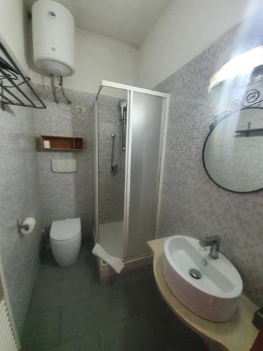 Un baño con ducha, lavabo e inodoro. en Sira House Milano, en Milán