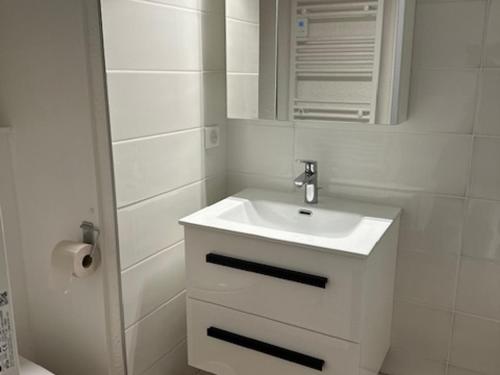 une salle de bain blanche avec un lavabo et un miroir dans l'établissement Appartement rénové 6 pers, 50m², Avoriaz Centre - 3 pièces, balcon, wifi, casier à skis - FR-1-633-31, à Avoriaz