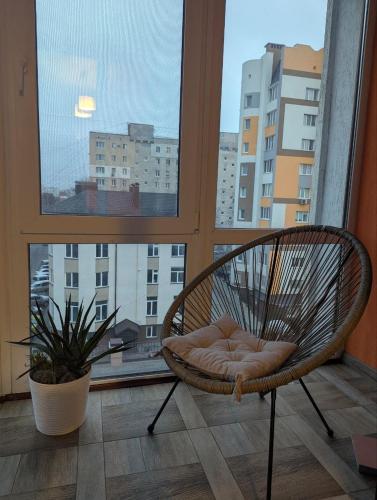 a wicker chair sitting in front of a window at 2-кім Новобудова, центр, провулок Лапушкіна , 9 in Khmelʼnytsʼkyy