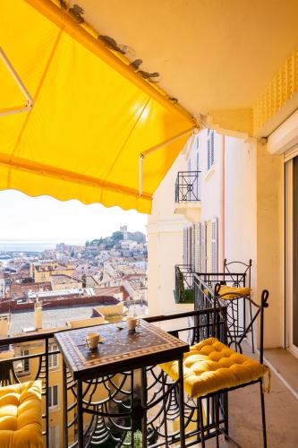 un balcon avec tables et chaises et vue sur la ville dans l'établissement Superbe T3 - 10 min Palais - Parking, à Cannes