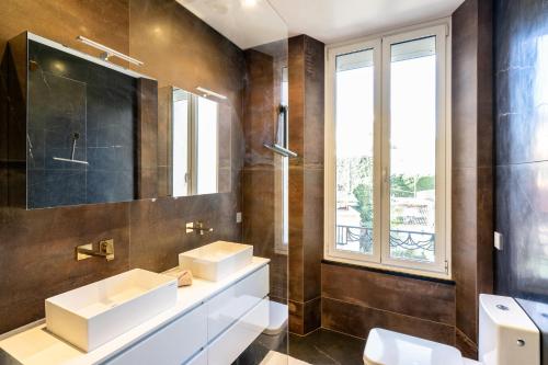 une salle de bain avec deux lavabos et un miroir dans l'établissement Superbe T3 - 10 min Palais - Parking, à Cannes