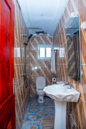 une salle de bain avec un lavabo et des toilettes dans l'établissement NAIVELI-PALM Appartement meublé sobre et chic, à Douala