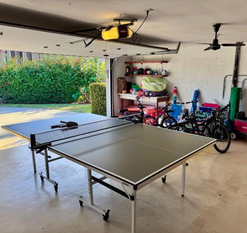a ping pong table in a garage with bikes at 5 Beds 3 BDR 2 Bath Heated Pool, Grill, Patio in Marco Island
