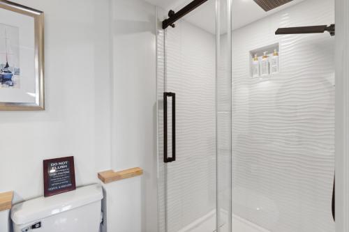 a white bathroom with a shower and a sink at Lakeshore Vermont in Colchester