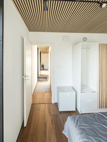 a bedroom with white walls and a wooden ceiling at Brenztal Eco Lodge in Giengen an der Brenz