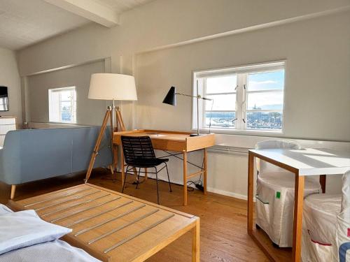 een kamer met een bureau en een bed met een raam bij Pier 18 im Pierspeicher in Kappeln