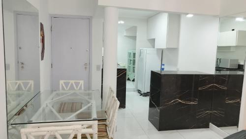 a kitchen with white walls and a black counter at Avelinos praia mar in Guarujá