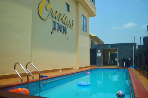 a swimming pool in front of a hotel at Caritas Inn Lekki in Lagos